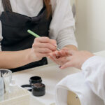 ジェルネイルを塗るネイリストの画像