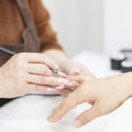 ジェルネイルを塗るネイリストの画像