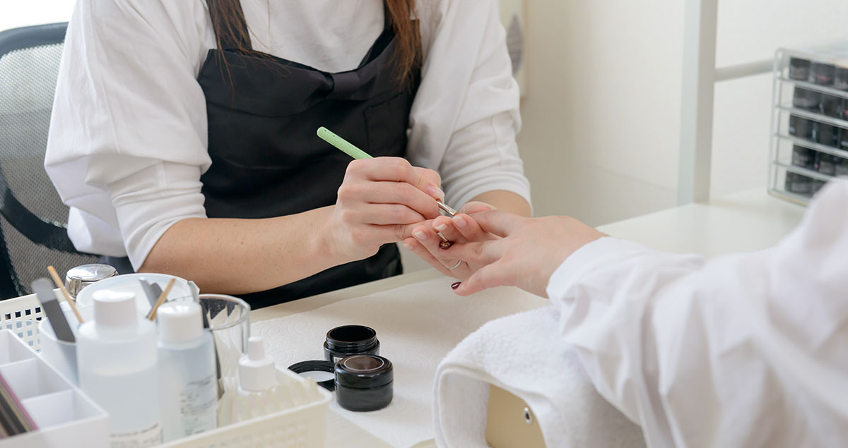 ジェルネイルを塗るネイリストの画像