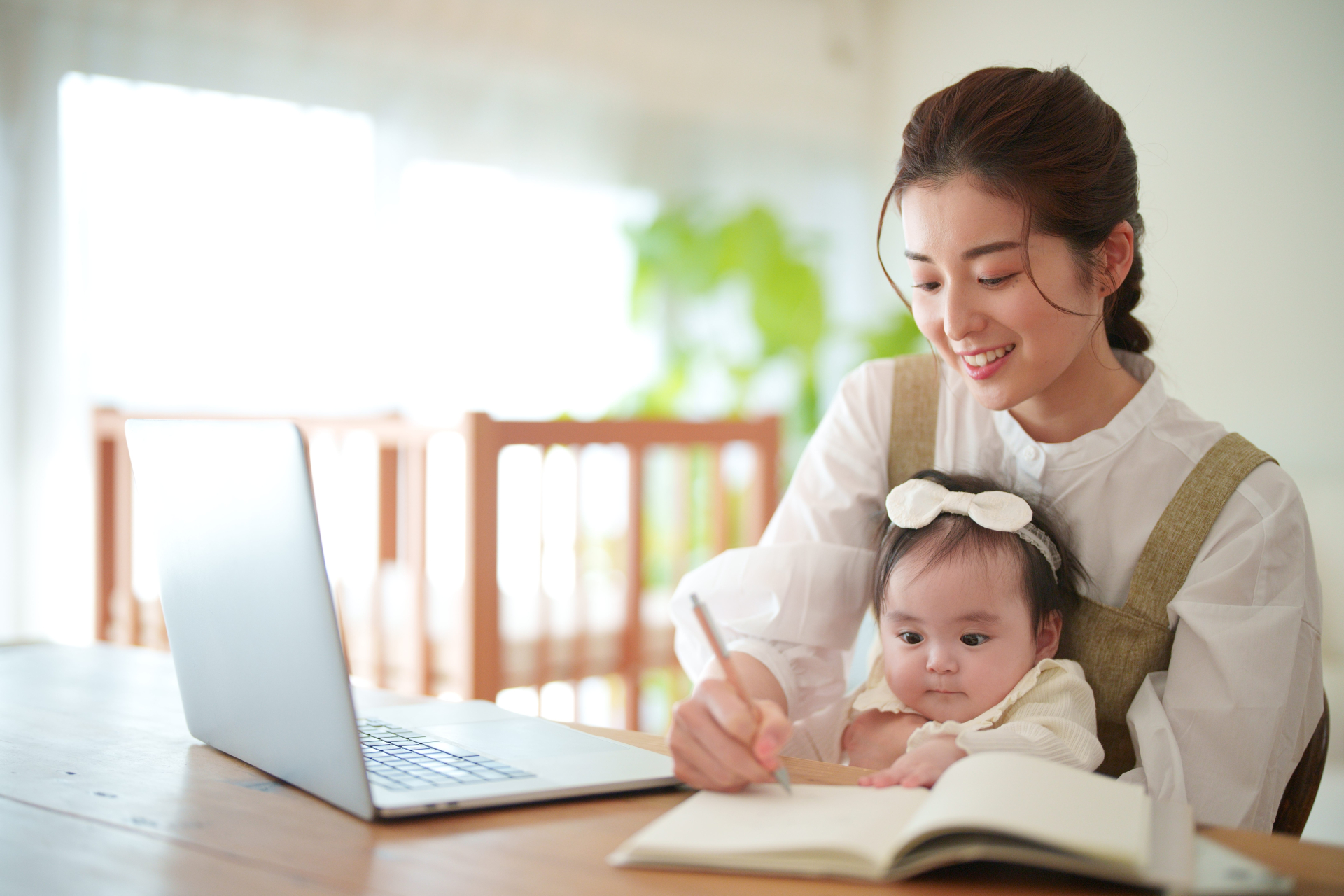 子育て中に資格の勉強をする女性の画像