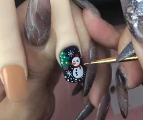 雪だるまのネイルアートを施す様子