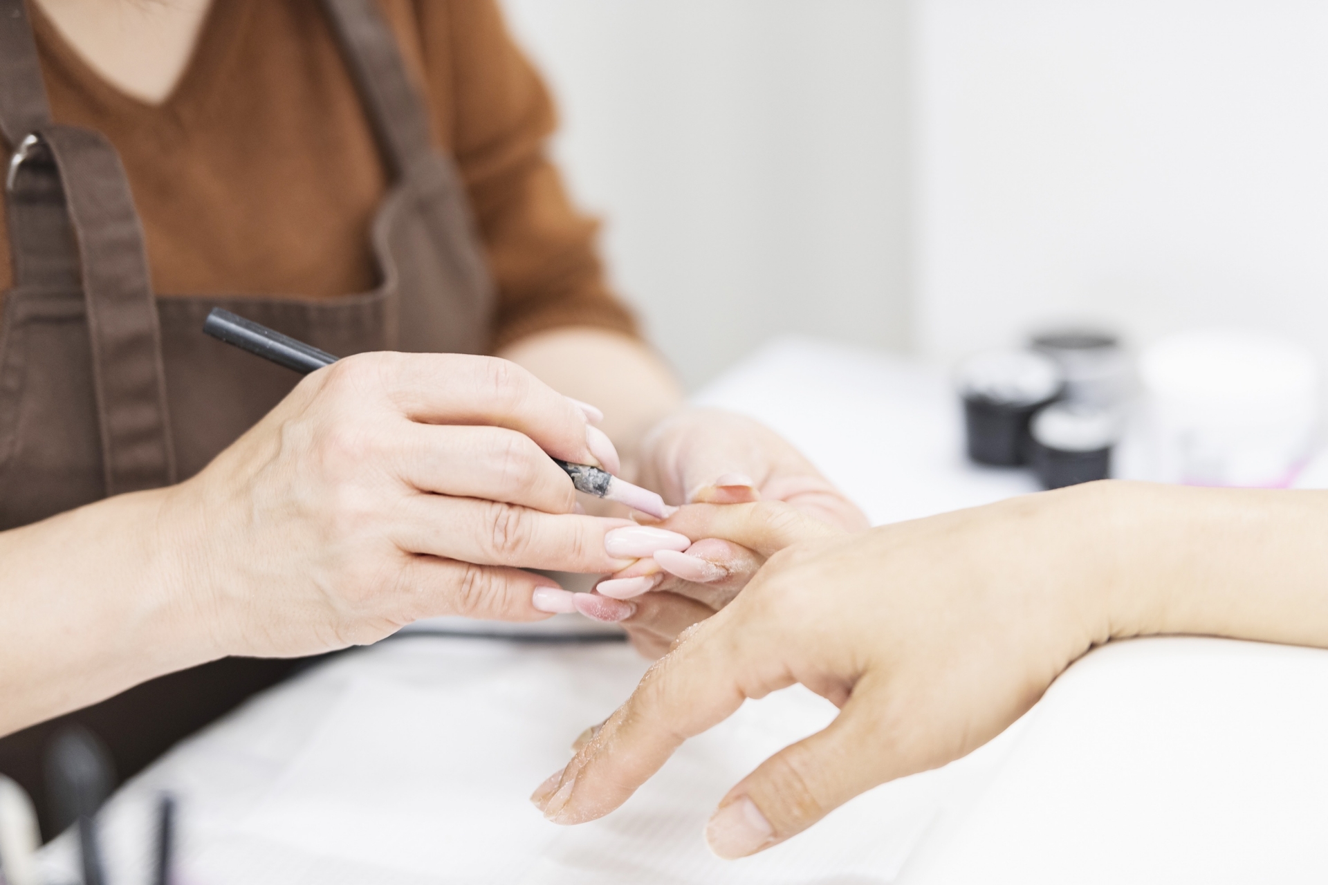 キューティクルケアをする40代女性ネイリストの画像