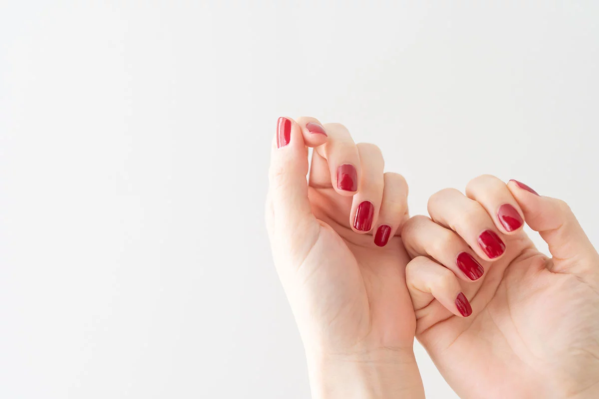 赤いジェルネイルが映える手元の画像