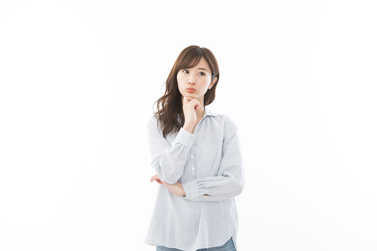 顎に手を当てて考えごとをしている女性