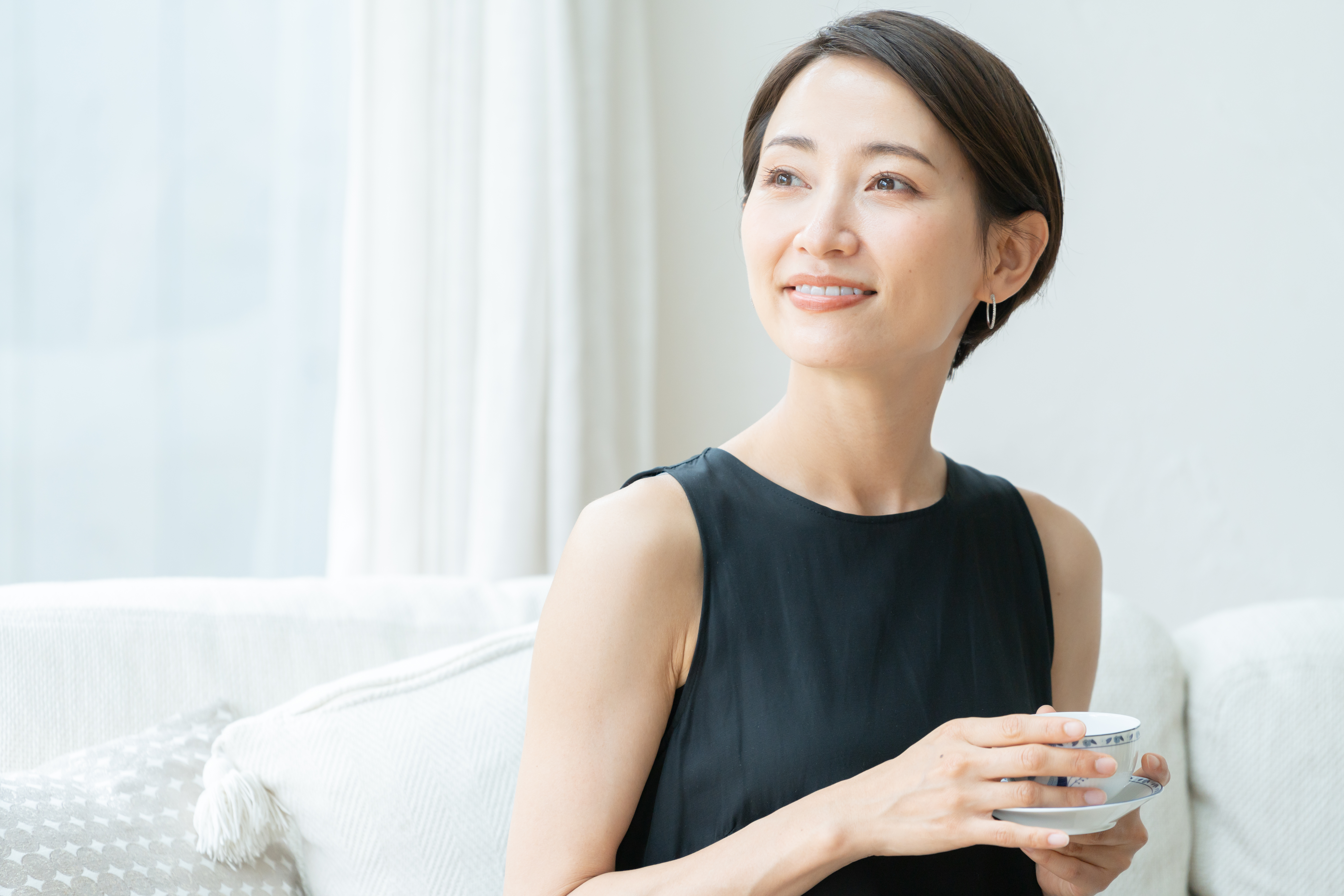 コーヒーを持ち微笑む女性