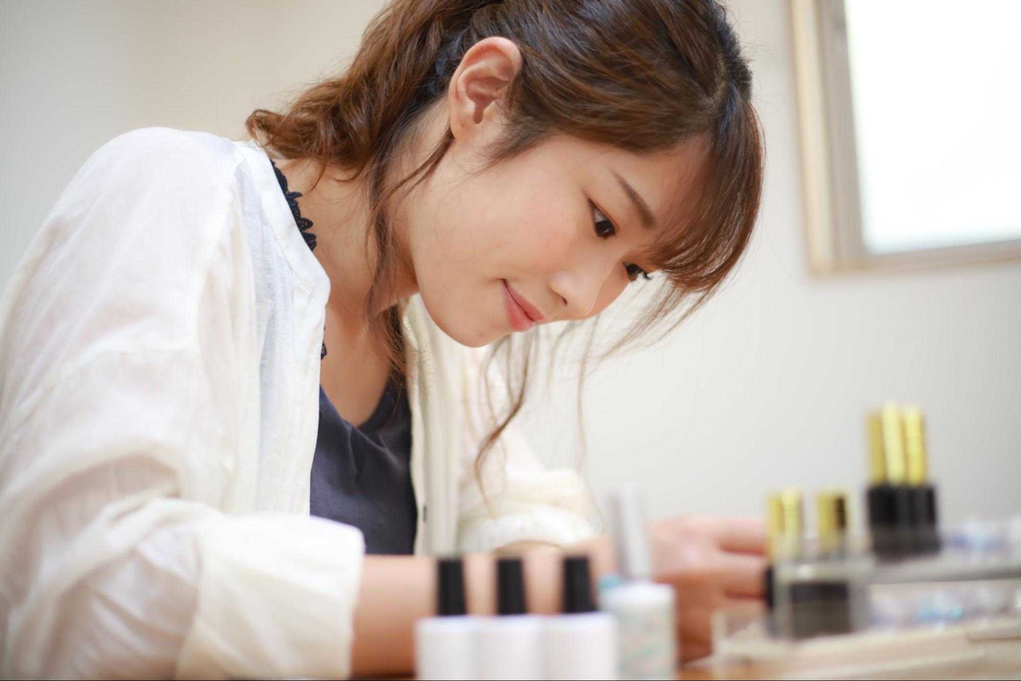 真剣な表情でネイルの勉強をする女性